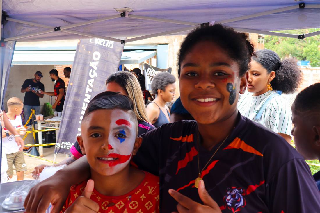 Dois meninos sorrindo com os rostos pintados em evento do projeto.