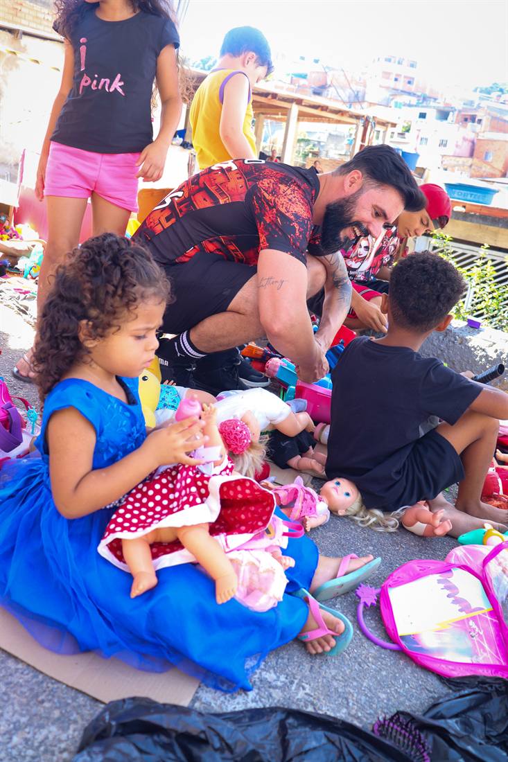 Menina abraça uma boneca recebida em ação de doação de brinquedos.
